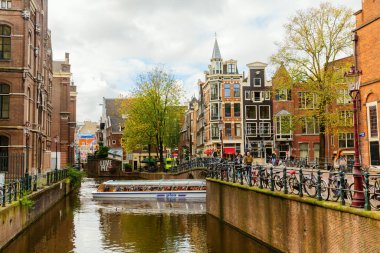 Amsterdam, Hollanda - 28 Ekim 2019: Amsterdam 'da kimliği belirsiz insanların bulunduğu tipik kanal manzarası. Amsterdam, Hollanda 'nın başkenti ve en kalabalık şehridir.