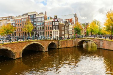 Amsterdam, Hollanda - 28 Ekim 2019: Amsterdam 'da kimliği belirsiz insanların bulunduğu tipik kanal manzarası. Amsterdam, Hollanda 'nın başkenti ve en kalabalık şehridir.