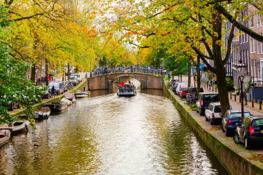 Amsterdam, Hollanda - 28 Ekim 2019: Amsterdam 'da kimliği belirsiz insanların bulunduğu tipik kanal manzarası. Amsterdam, Hollanda 'nın başkenti ve en kalabalık şehridir.