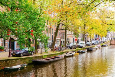 Amsterdam, Hollanda - 28 Ekim 2019: Amsterdam 'da kimliği belirsiz insanların bulunduğu tipik kanal manzarası. Amsterdam, Hollanda 'nın başkenti ve en kalabalık şehridir.