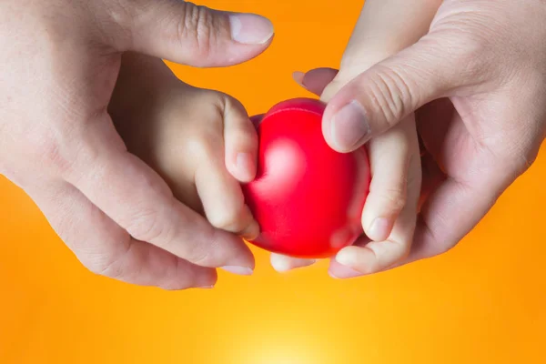 Padre tenere mano bambino su sfondo arancione — Foto Stock