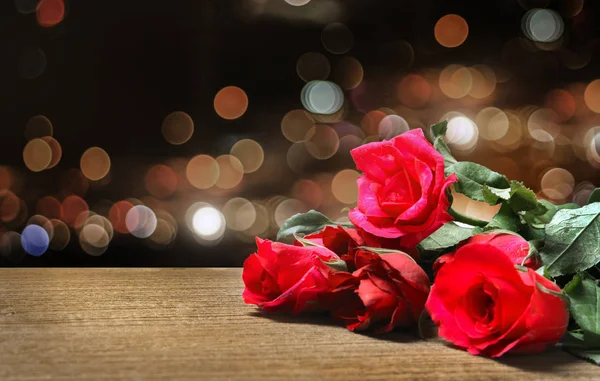 Czerwona róża na tabeli noc stroną — Zdjęcie stockowe