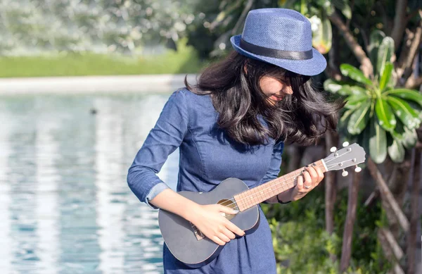 Asiatisk pige spille sang med ukulele - Stock-foto