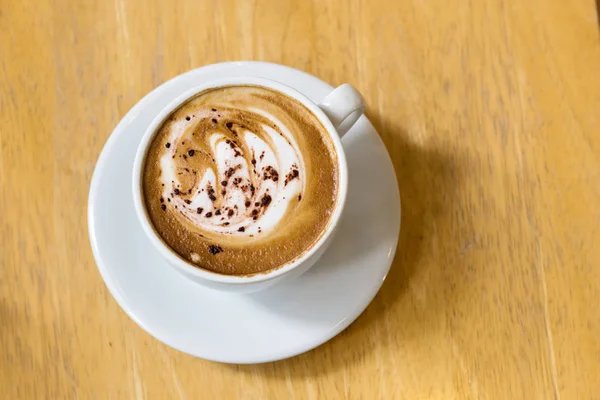 Lattee kunst koffie op houten tafel — Stockfoto