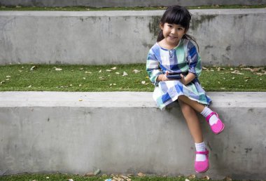 Asyalı çocuk oynamak Bahçe park akıllı telefon