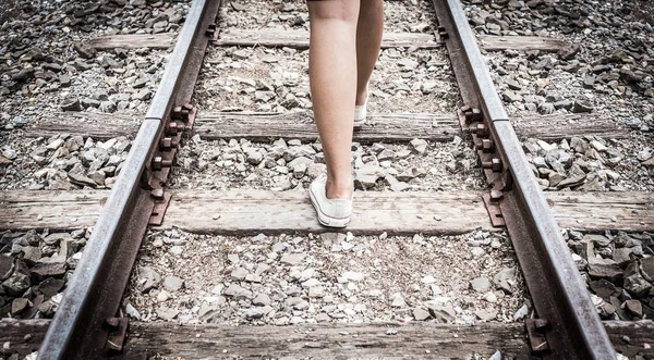 teenage feet walk on old railway