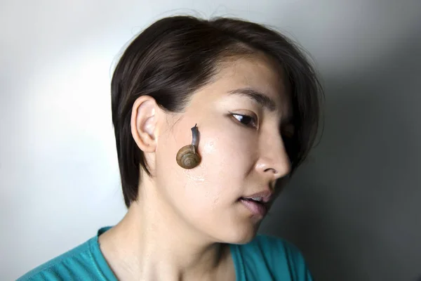 Snail massage on face of asian woman — Stock Photo, Image