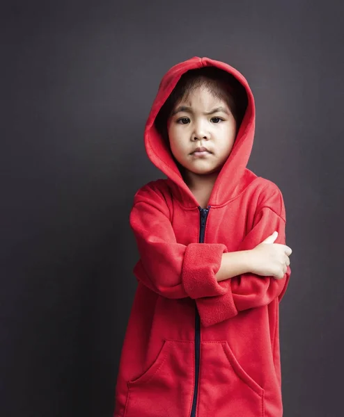 不機嫌そうな顔でフードを着ているアジアの少女 — ストック写真