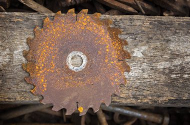 old rusty saw  on disk texture with wood background clipart