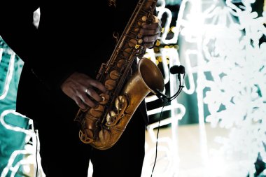 Saksafoncu açık havada saksafonla müzik çalıyor.