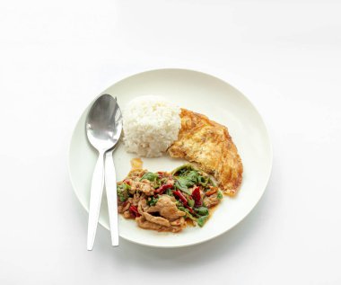 Popüler Tayland yemeği menüsü, baharatlı fesleğenli domuz eti ve omlet yumurtalı beyaz arka planda servis. 