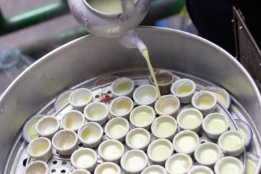 Sıcak buharlı seramik bardakla haşlanmış hindistan cevizli tatlı pişirin.