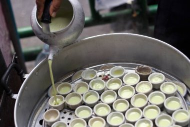 Haşlanmış tatlı hindistan cevizli tatlı ve sıcak buharlı seramik bardak.