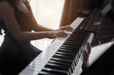 El çocukları piyano çalmayı geleceğin mesleği için müzik yeteneğini geliştirmek adına öğrenirler..
