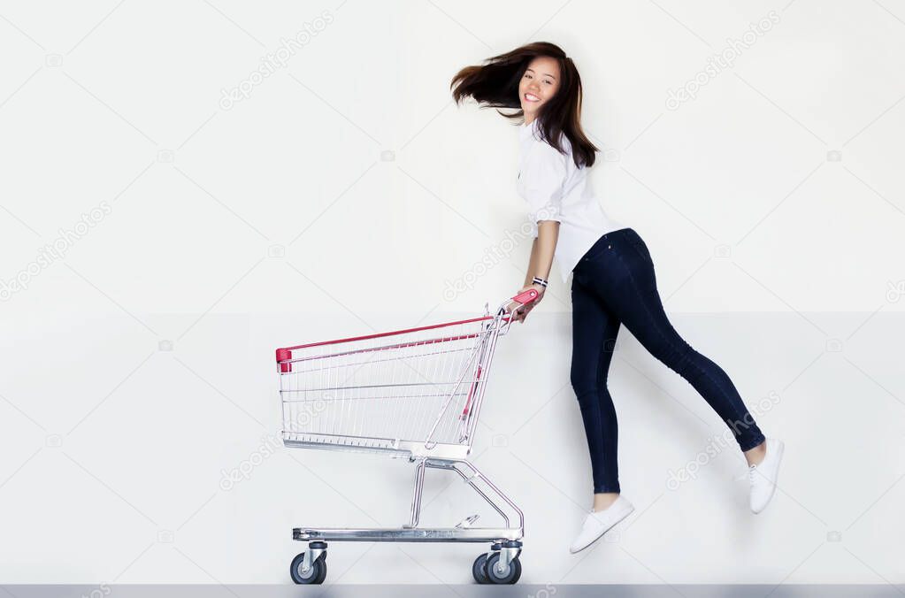happy asian woman love shopping action with shopping cart on white background.