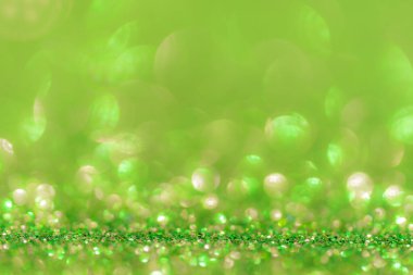Parıltı, ışıltı çözünmüş bulanık pastel yeşil arka plan ve bokeh ışıkları