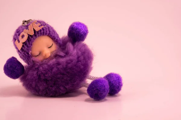 Amulet, talisman a good luck charm with love inscription. A fluffy sleeping purple baby. Copy space