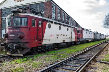 Arka arkaya çoklu kırmızı ve beyaz dizel lokomotifler. Demiryolu önde.