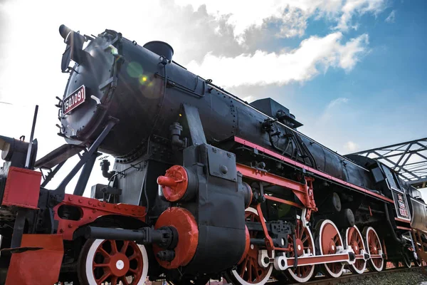 Buharlı lokomotif, arka planda motor ve mavi gökyüzü. Mercek parlaması