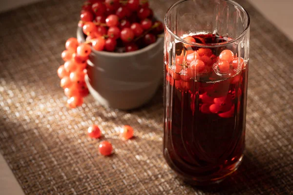 Kırmızı üzümlü taze meyve ve içecek bir masada. Huysuz günbatımı ışığı