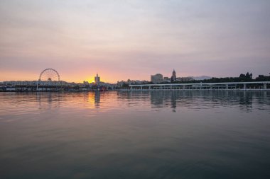 Altın saatinde muhteşem gün batımı manzarası ve arka planda binalar.
