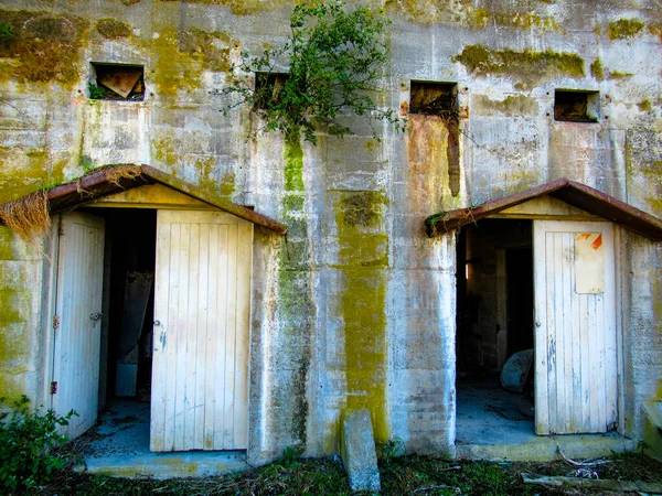 Two doors on the exterior of the historic concrete stone crushing building which is now abandoned and derelict