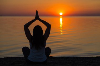 dziewczyna robi joga na zachodzie słońca