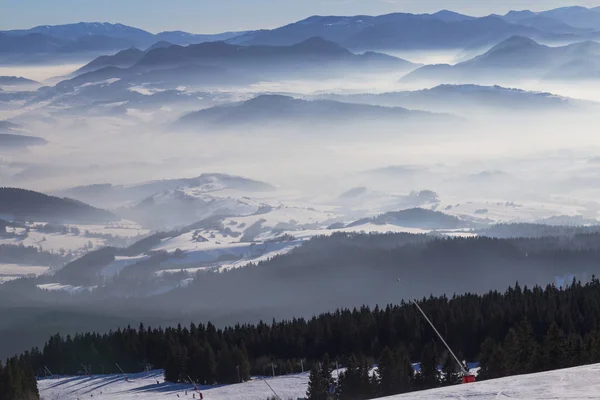 从滑雪斜坡上的积雪覆盖和雾谷的看法 — 图库照片
