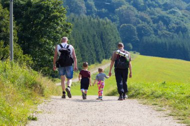29 Ağustos 2016. Tatras, Slovakya, Trencin bölge. Sırt çantaları ve çocukları ile iki adam yol boyunca bir yaz gününde dağlara gidelim. Sportif, sağlıklı bir aile, aktif bir yaşam tarzı, sağlıklı çocuk, aile değerleri yetiştirme kavramı