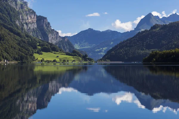 Dağ gölü Klontalersee görkemli Dağları'nın arka plan üzerinde su ve parlak bulutlu gökyüzü yansıtıyordu. Glarus Canton. İsviçre Alpleri. İsviçre. Turizm