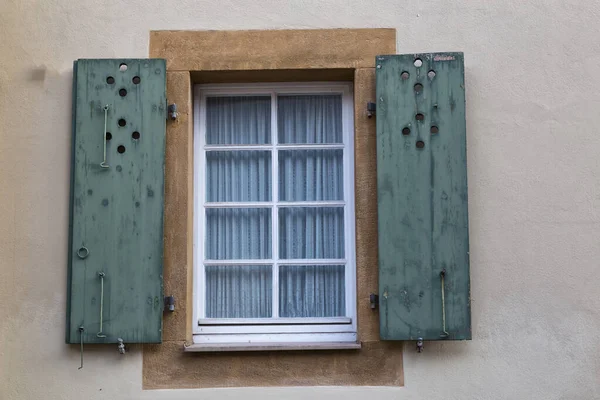 Старое красочное окно с открытыми деревянными ставнями на стене дома — стоковое фото