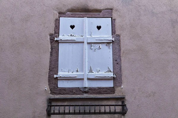 Antigua ventana con persianas blancas agrietadas en la pared de color — Foto de Stock
