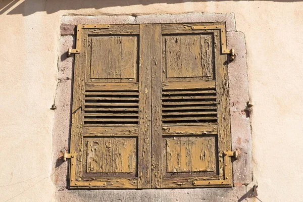 Antigua ventana con persianas agrietadas en la pared antigua de color — Foto de Stock