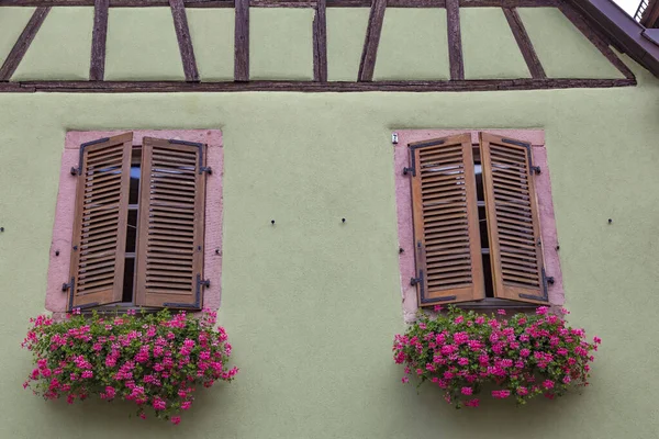 Duas janelas com persianas de madeira fechadas na parede antiga — Fotografia de Stock