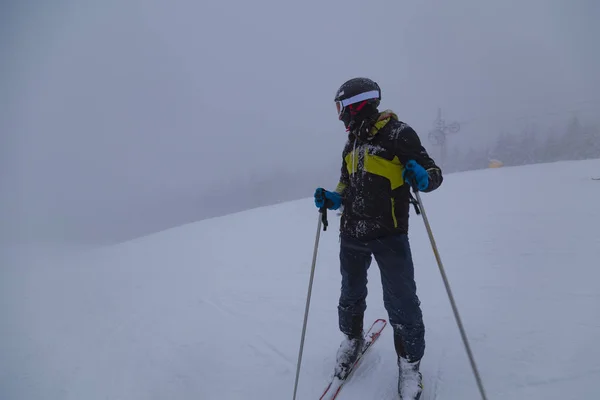 Narciarz na stoku narciarskim we mgle. — Zdjęcie stockowe