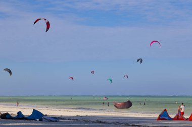 Tanzanya 'nın Jambiani köyü yakınlarındaki Zanzibar adasının 14.02.2019 Sahili. Dünyanın dört bir yanından gelen turistler, sörfçüler, uçurtma sörfü ile meşgul oluyorlar. Dünyanın ünlü uçurtma sörfü tatili yeri.. 
