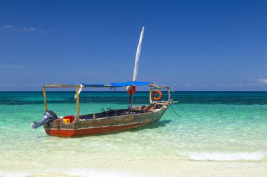 Eski bir Afrika teknesi, yakın plan. Mavi parlak arka planda, gök mavisi okyanus yüzeyinde bir tekne. Zanzibar adası kıyıları, Afrika