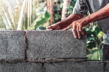 İnşaat işçileri tuğla bloklarla beton duvarlar inşa ediyorlar..