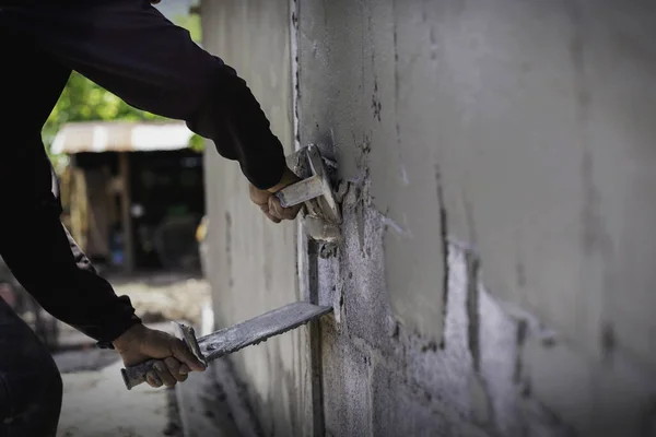 Mason plastering the concrete to build wall, Construction