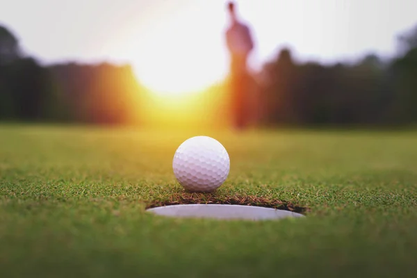 Golf topları ve golf sopası yeşil çimlerin üzerinde parlak güneş ışığı