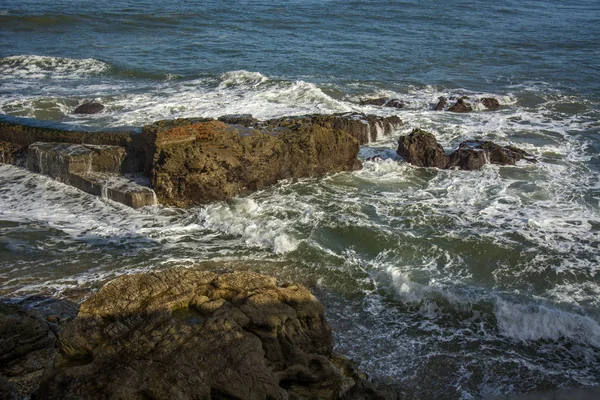 有海水 海浪和阳光的几块岩石 — 图库照片