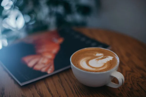 Masada dergi olan bir kapuçino.