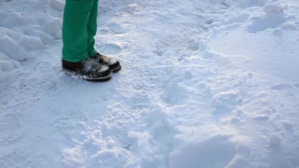 Een man met bevroren benen probeert warm te blijven. — Stockvideo