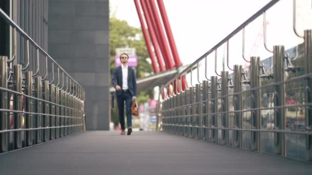 L'uomo che cammina sul ponte del Business Center e si guarda intorno — Video Stock