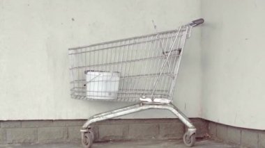 Duvarın yanındaki alışveriş arabası.