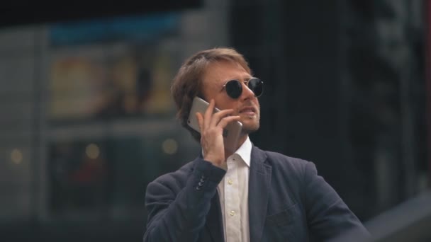 De man aan de telefoon en glimlachend — Stockvideo