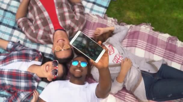 Group of young students take a selfie while lying on the grass — Stock Video