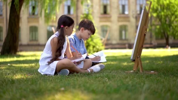 Niño y niña dibujando al aire libre . — Vídeos de Stock