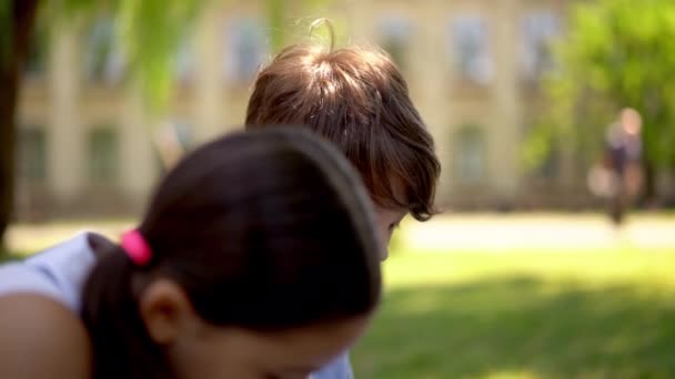 Enfants rencontrant enseignant assis dans le parc — Video
