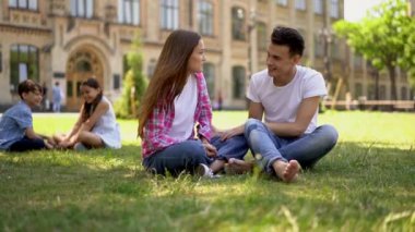 Birbirinden hoşlanan bir erkek ve bir kız sınıf arkadaşı bir çift lise öğrencisini izliyor ve okulun yakınındaki çimlerin üzerinde onlara sessizce gülüyorlar. Yavaş çekim.